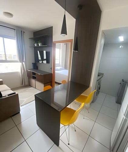 uma cozinha com uma secretária e cadeiras amarelas num quarto em Ap c/Garagem, Elevador, Cozinha Completa, Lava e Seca, Jr Catito em Brasília