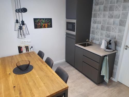 een keuken met een houten tafel en een keuken met een wastafel bij Family Inn Kaatsheuvel in Kaatsheuvel