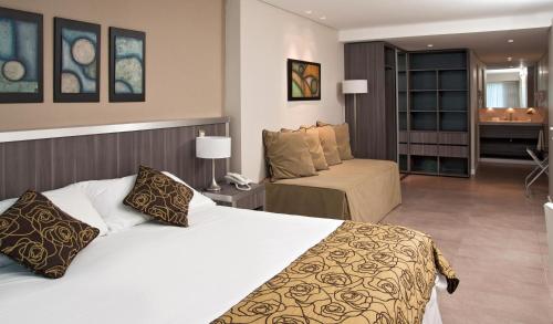 a hotel room with a bed and a couch at Uthgra Presidente Perón in Mar del Plata