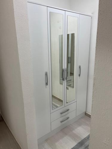 baño con armario blanco con espejo en Caracas Aparto Suite La Boyera, en Caracas
