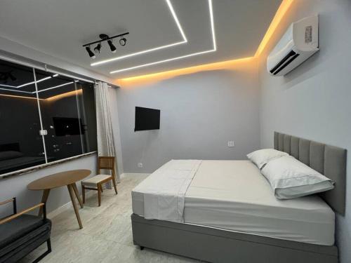 1 dormitorio con cama, mesa y ventana en Studio Dowtown tech Rio, en Río de Janeiro