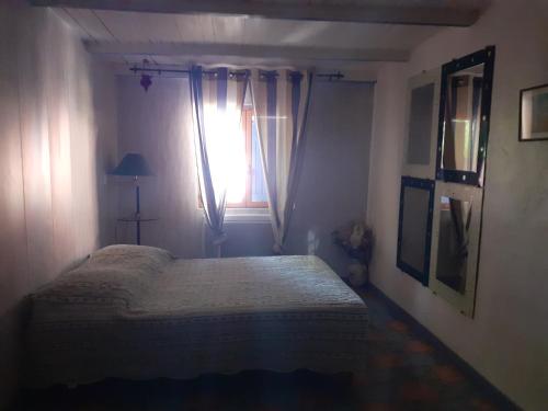 1 dormitorio con cama y ventana en Maison d'Hôtes La Douloire, en Pernes-les-Fontaines