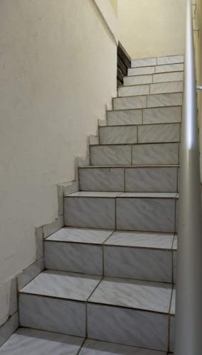 eine Treppe in einem Zimmer mit weißen Wänden in der Unterkunft Casa na Barra de São Miguel -AL in São Miguel dos Campos