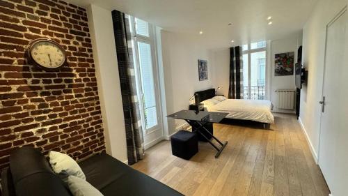 een woonkamer met een bank en een bakstenen muur bij Gorgeous Paris Eiffel Tower in Parijs
