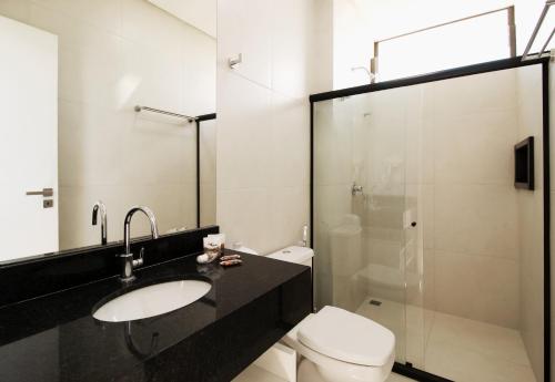 a bathroom with a toilet and a sink and a shower at Ilhéus Praia Hotel in Ilhéus