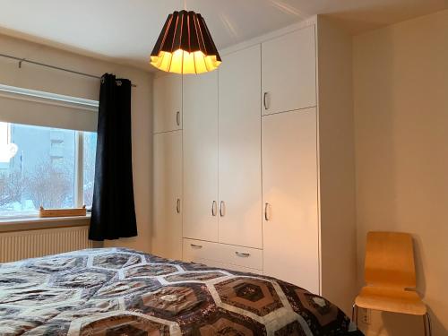 a bedroom with a bed and a chair and a lamp at Great apartment in Akureyri in Akureyri