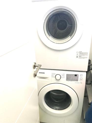 a washer and dryer in a bathroom with a washing machine at Blue Lagoon seafront apartment in Flic-en-Flac