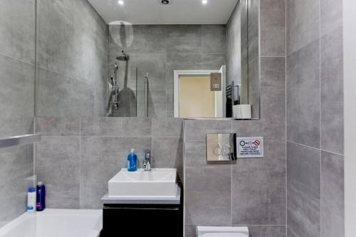 a bathroom with a sink and a mirror at Large 2bed Kensington in London