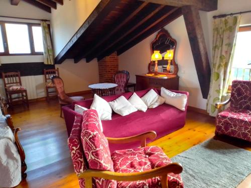 uma sala de estar com um sofá vermelho e cadeiras em Casa Mari Paz Trasvía em Comillas