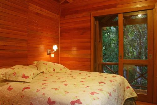 a bedroom with a bed and a window at Chalets do Vale in Gramado