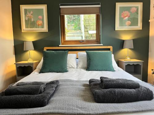 a bedroom with a bed with two lamps and a window at Wellinghill Lodge in Cheltenham