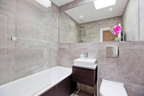 a bathroom with a sink and a toilet and a tub at Super 2bed Kensington in London