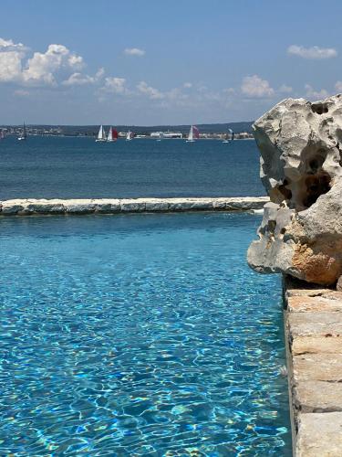 a pool of blue water with boats in the ocean at Les pieds dans l’eau in Sète