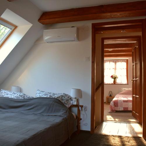 a bedroom with a bed and a window at Bogáncs Vendégház - Nagybörzsöny in Nagybörzsöny