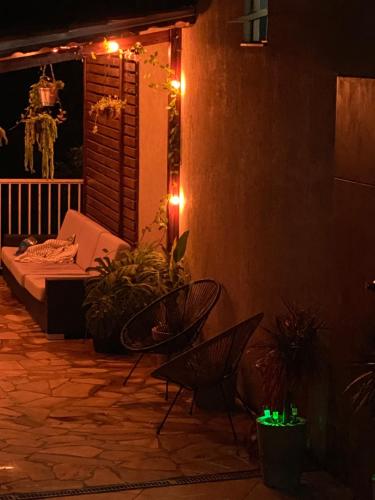 a patio with a bed and chairs and lights at Casa da Renata in São Lourenço