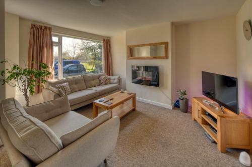 a living room with a couch and a tv at Henry's Bed and Breakfast in Bath