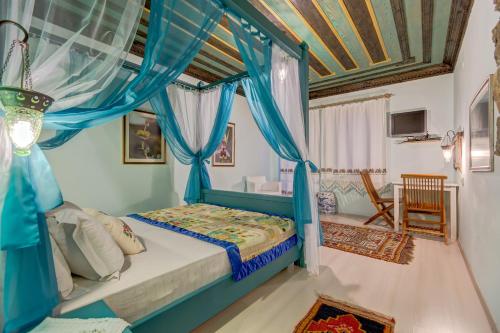 a bedroom with a canopy bed with blue drapes at Datca Villa Asina in Datca