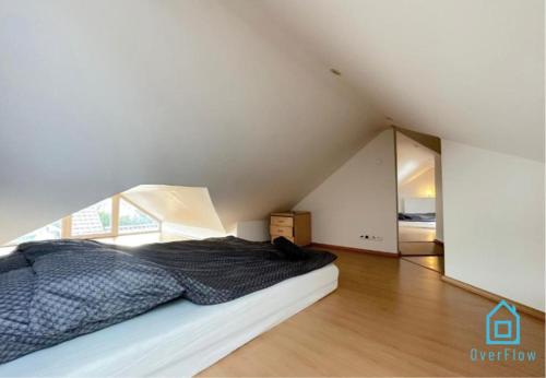 an attic bedroom with a bed and a mirror at Attic Room in Gdańsk