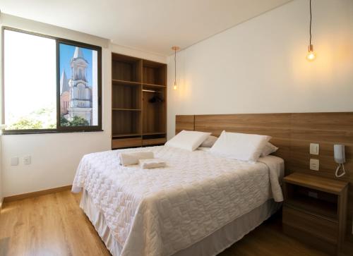 a bedroom with a large bed and a window at Ilhéus Praia Hotel in Ilhéus