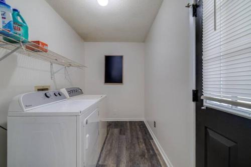 a laundry room with a washer and dryer next to a window at The Peach Family Friendly Oasis in Savannah