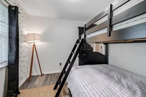 a bedroom with a bunk bed and a lamp at The Peach Family Friendly Oasis in Savannah