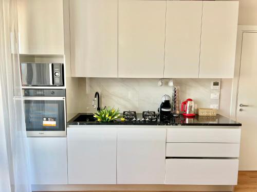 a white kitchen with white cabinets and appliances at Corso Venezia in Mestre