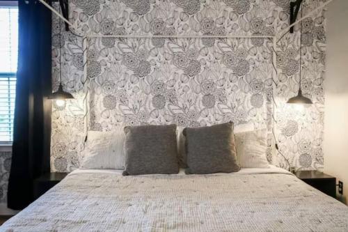 a bedroom with a white bed with a floral headboard at Honey, I’m Home near Savannah - Seen on HGTV in Savannah
