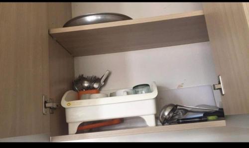 a cupboard filled with dishes and utensils at Condo units in Mabolo Garden Flats Cebu in Cebu City