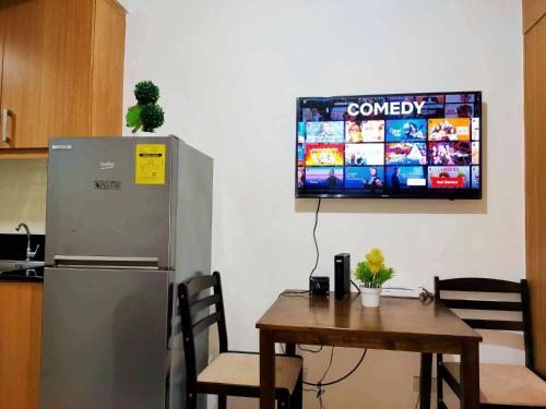 uma cozinha com uma mesa e uma televisão na parede em Shell Residences condotel em Manila