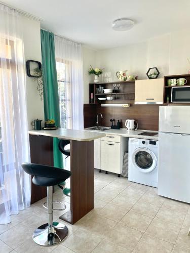 a kitchen with a table and a washing machine at Style Apartment in Sveti Vlas ( Kompleks Morski Far ) in Sveti Vlas