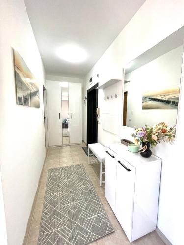 a bathroom with white walls and white cabinets and a rug at Style Apartment in Sveti Vlas ( Kompleks Morski Far ) in Sveti Vlas