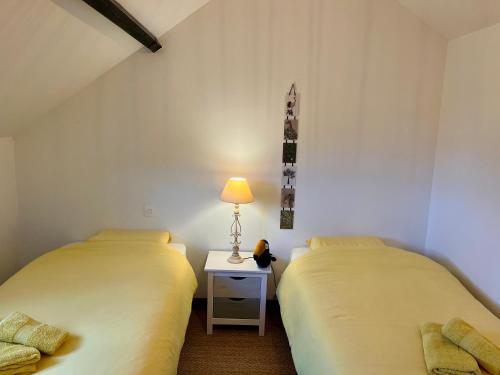 deux lits côte à côte dans une pièce dans l'établissement Maison de centre-village 
