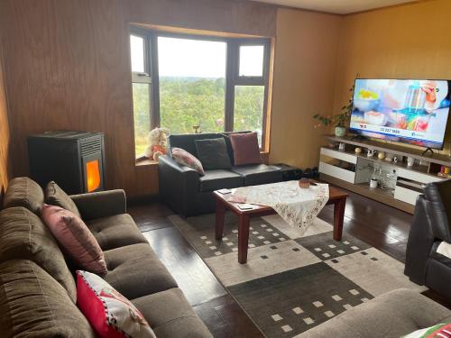 a living room with a couch and a tv at Casa Sra Oti, Tipo Hostal con vista al mar Puerto Montt - CHINQUIHUE in Puerto Montt