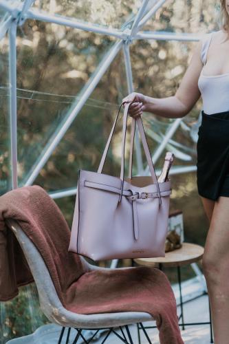 a woman holding a pink handbag on a chair at The Forest Dome Tsitsikamma in Stormsriviermond