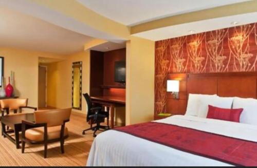 a hotel room with a bed and a desk and a table at Courtyard by Marriott Buffalo Amherst/University in Amherst