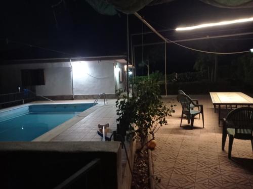 - une piscine avec une table et des chaises la nuit dans l'établissement Chalet Venta del Aire, à Lanjarón