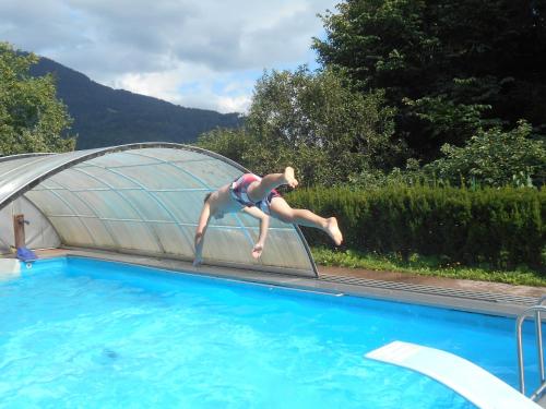 osoba skacząca z deski do nurkowania do basenu w obiekcie Umundumhütte w mieście Katsch an der Mur