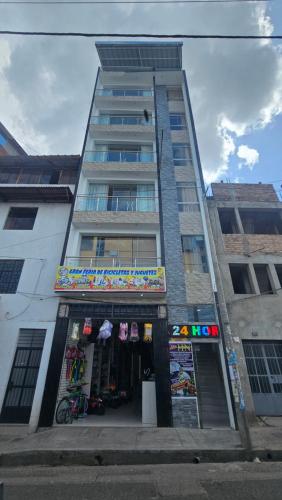 un edificio alto con una tienda delante en HOTEL NILA en Cajamarca