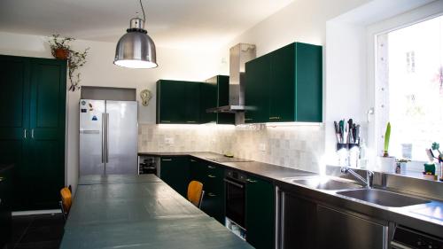 a kitchen with green cabinets and a sink at Casa Gatti BnB Gastronomia e Benessere in Motto