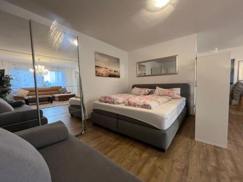 a bedroom with a bed and a living room at Kuschelnest 'Seebrise' mit Parkplatz in Überlingen