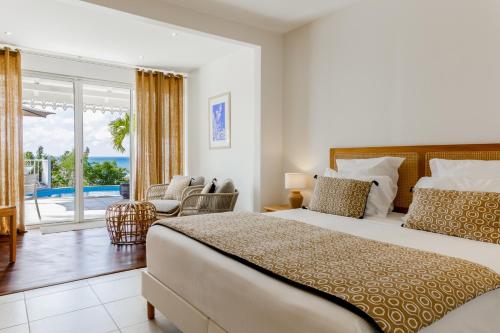 a bedroom with a bed and a view of the ocean at H&ocirc;tel Amaudo in Saint-Fran&ccedil;ois