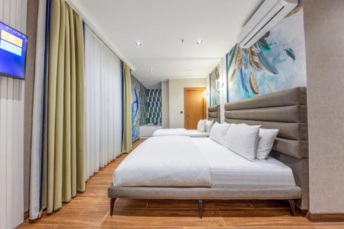 a bedroom with two beds and a painting on the wall at Premium Dem Hotel - Istanbul Airport in Arnavutköy