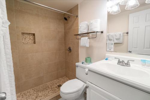 a bathroom with a toilet and a sink and a shower at Beach Vibes with Great Amenities on the 2nd Floor in Pawleys Island