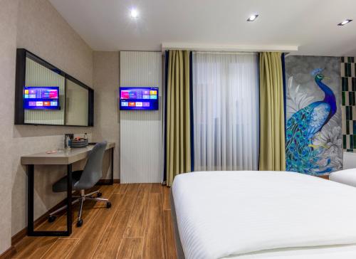 a hotel room with a bed and a desk and a computer at Dem Premium Hotel - Round Trip Airport Service - Istanbul International Airport in Arnavutköy