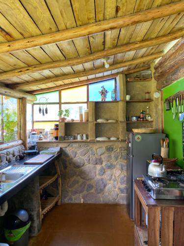 a kitchen with a stone wall and a refrigerator at Eco hause Ollantaytambo in Ollantaytambo