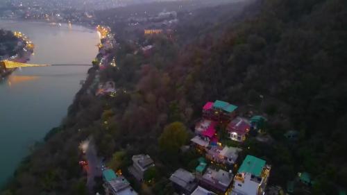 uma vista aérea de um edifício numa colina junto a um rio em Swiss Cottage and Spa by Salvus em Rishikesh