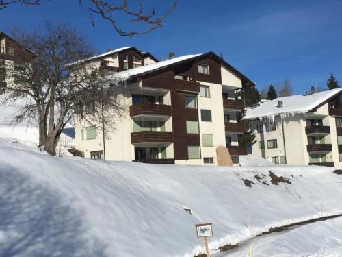 a snow covered parking lot in front of a building at Casa Splendusa - sonnige Wohnung in Brigels in Brigels