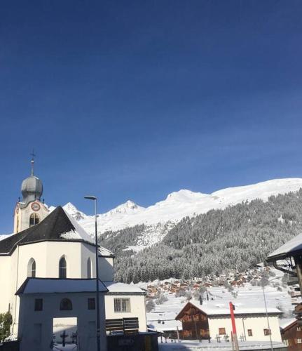 a white church with a snowy mountain in the background at Casa Splendusa - sonnige Wohnung in Brigels in Brigels