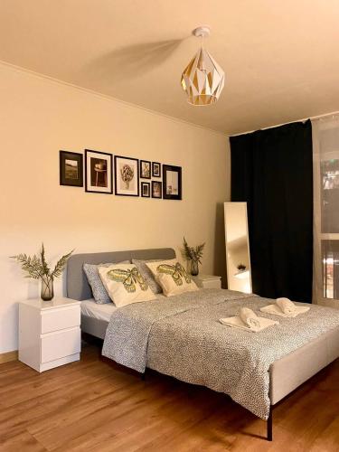 Schlafzimmer mit einem Bett und einem Kronleuchter in der Unterkunft HALBY rooms Rondo ONZ in Warschau