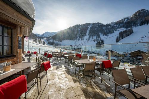 un restaurante con mesas y sillas en una pista de esquí en Hotel Alpenhof Superior en Zauchensee